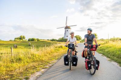 Radfahrer mit Windmhle in Flandern