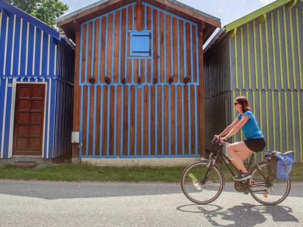 Bunte Holzhuser in Biganos mit Radfahrerin