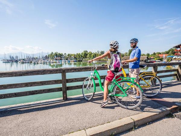 Radfahrer in Seebruck blicken auf den Chiemsee