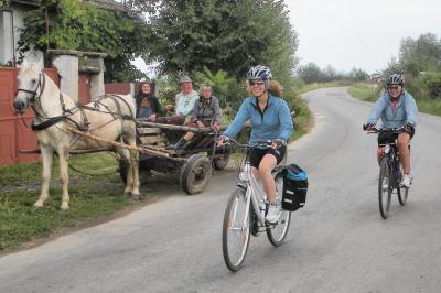 Radfahrer passieren einen Pferdewagen