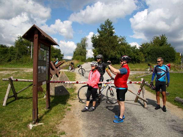 Radfahrer bei Schild mit Info ber den Eisernen Vorhang